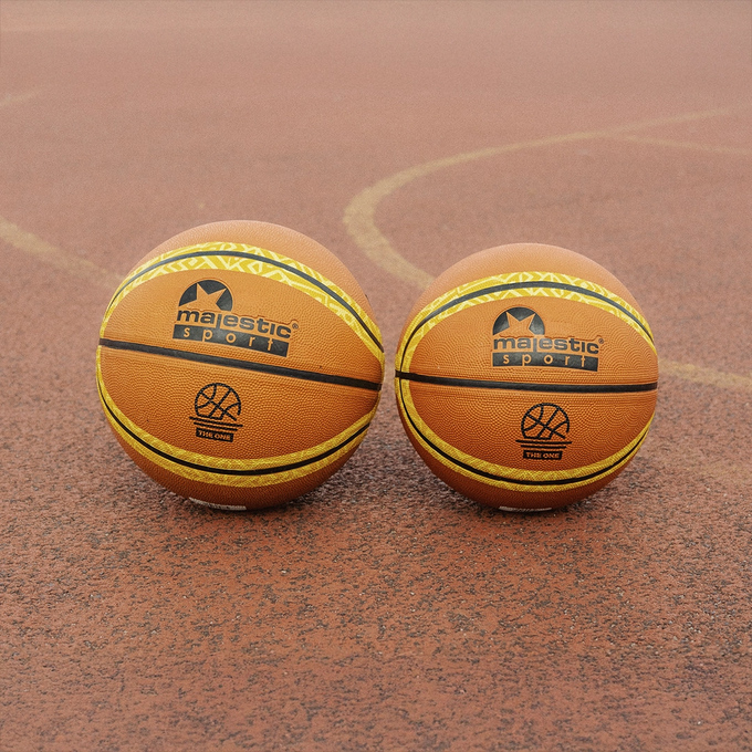 Dwie piłki do koszykówki, Majestic Sport TheOne, pomarańczowa, obok siebie na boisku do gry