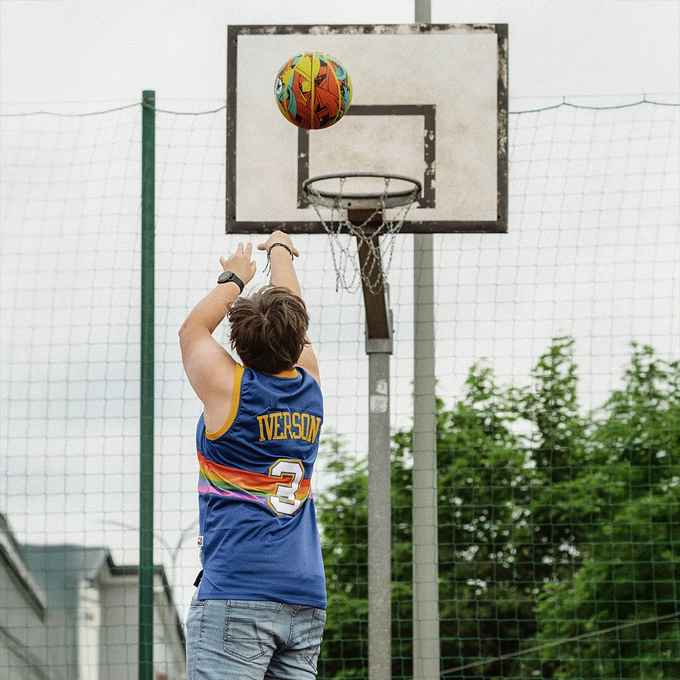 Kobieta gra w koszykówkę piłką do koszykówki, Majestic Sport Arrow multicolor, rzuca do kosza