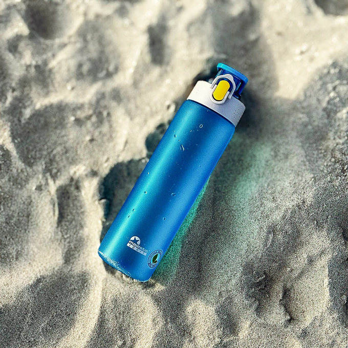 Niebieska matowa butelka tritanowa na wodę o pojemności 750ml, Majestic Sport Okosei Mat, na piasku na plaży