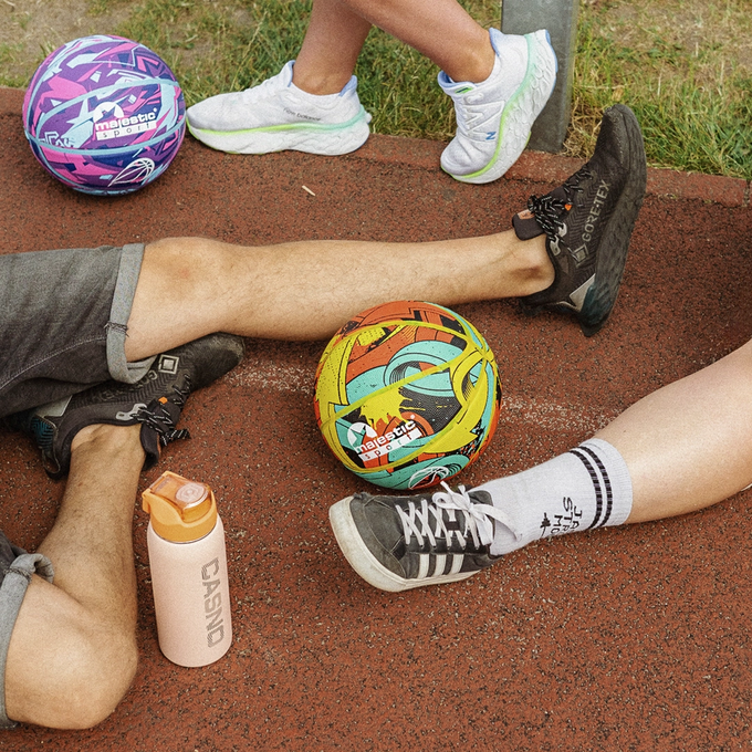 Postacie siedzą na boisku do koszykówki, a obok nich leżą piłki do koszykówki, Arrow i Galaxy, Majestic Sport